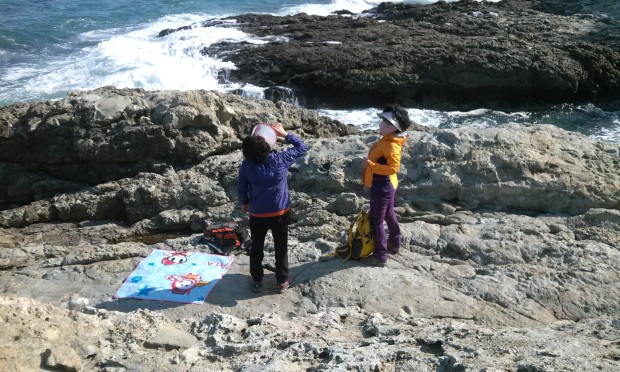 Quintessential Korean ajummas having  a picnic on hard rocks while being covered head to toe lest the sun touch any speck of their skin.